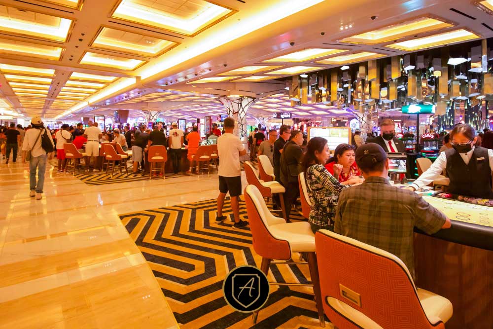 In "How-Executive-Protection-Reduces-Risk-2," security strategies are highlighted for lively spaces like casinos, where people gather at gaming tables and slot machines under bright lights, ensuring safety for both visitors and staff.