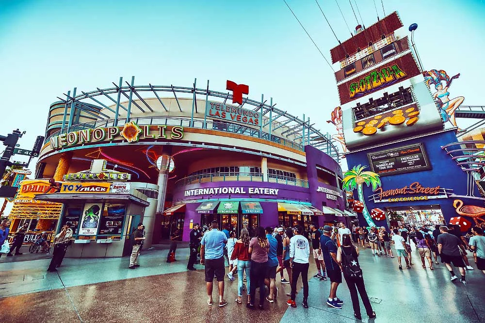 Crowds enjoy Fremont Street Experiences vibrant shops and neon signs, including an international eatery, all safeguarded under a bright sky by Executive Protection & Bodyguards in Las Vegas—see executive-protection-page-2 from Alexios Security Solutions.