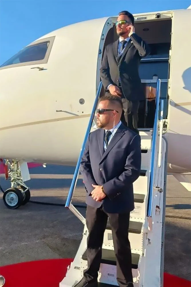 Two men in suits and sunglasses stand on the steps of a private jet, displaying the sharp, professional presence of Executive Protection & Bodyguards in Las Vegas from medium-carousel-1.
