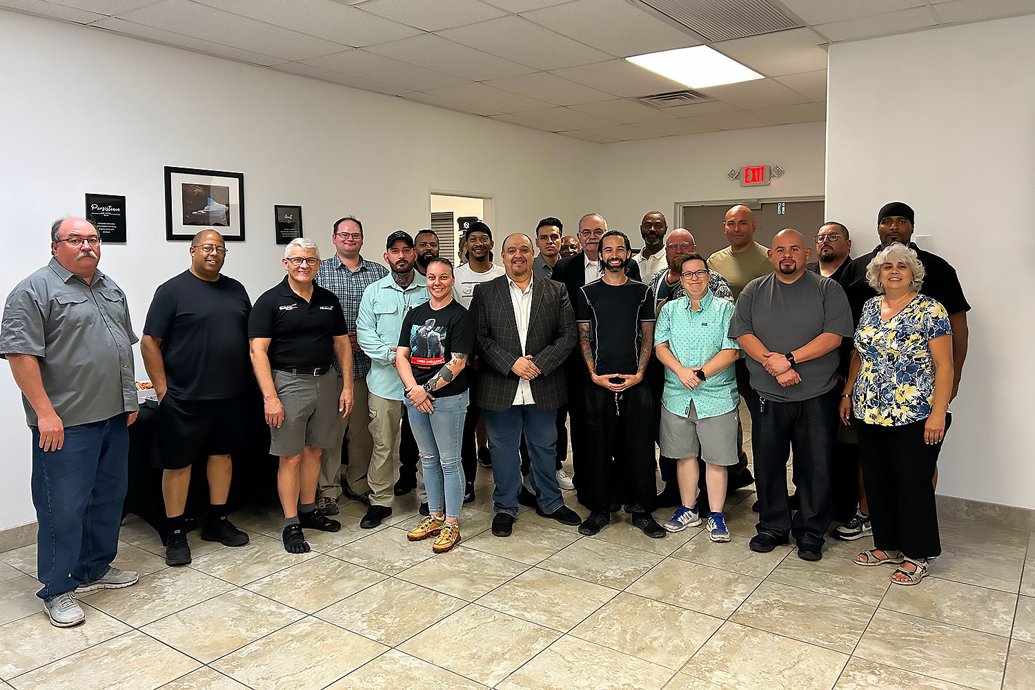 A group of 20 adults of varied ages and appearances smiles together in an office with tiled floors and white walls, featuring Antonio Guadagni and Christina Guadagni from the Alexios-Security-Team, experts in executive protection Nevada. A group of 20 adults of varied ages and appearances smiles together in an office with tiled floors and white walls, featuring Antonio Guadagni and Christina Guadagni from the Alexios-Security-Team, experts in executive protection Nevada.