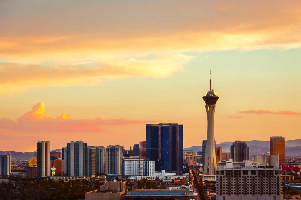 Alexios-security-solutions-las-vegas-nevada: Las Vegas skyline at sunset with the Stratosphere Tower, hotels, and casinos below vibrant orange and yellow Nevada clouds, mountains in the distance. Alexios-security-solutions-las-vegas-nevada: Las Vegas skyline at sunset with the Stratosphere Tower, hotels, and casinos below vibrant orange and yellow Nevada clouds, mountains in the distance.