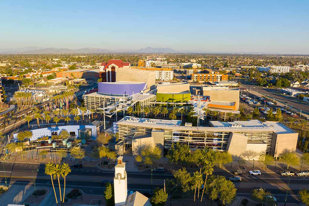 Aerial view of Reno’s modern cityscape—colorful buildings, palm trees, and busy streets under blue skies with mountains in the distance—protected by Alexios-security-solutions-mesa-arizona. Aerial view of Reno’s modern cityscape—colorful buildings, palm trees, and busy streets under blue skies with mountains in the distance—protected by Alexios-security-solutions-mesa-arizona.
