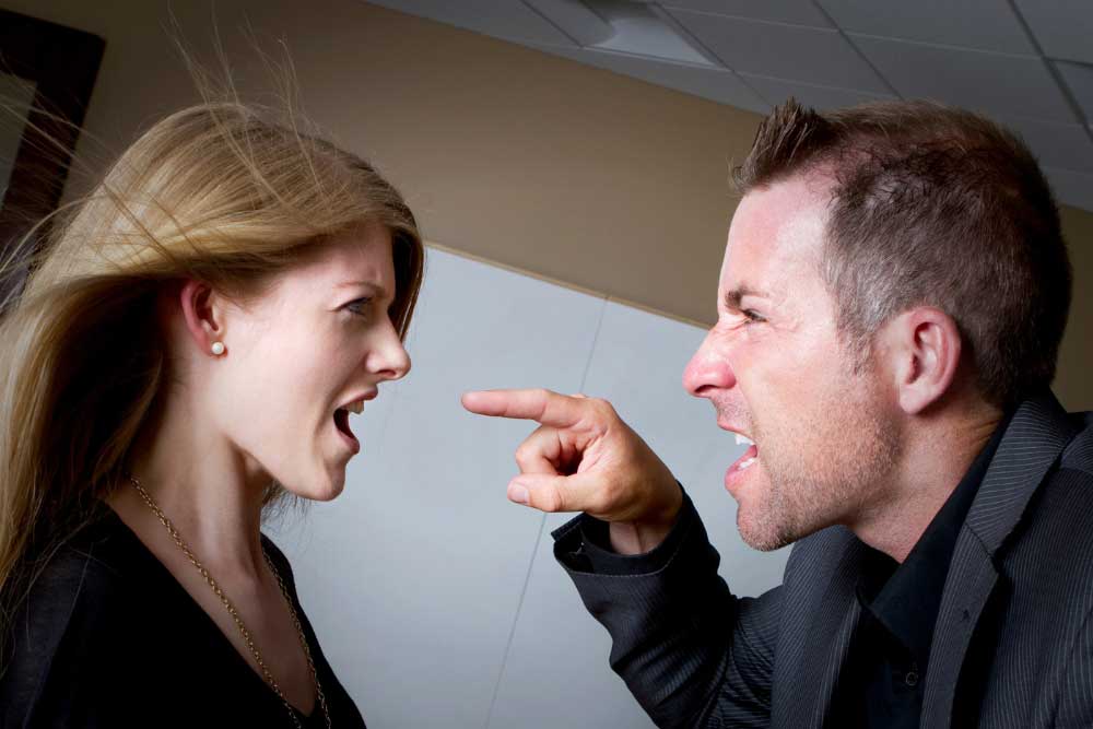 A man shouts and points at an upset woman during a heated argument indoors, highlighting the importance of hostile-termination-training-5 in Arizona for managing workplace conflicts professionally. A man shouts and points at an upset woman during a heated argument indoors, highlighting the importance of hostile-termination-training-5 in Arizona for managing workplace conflicts professionally.