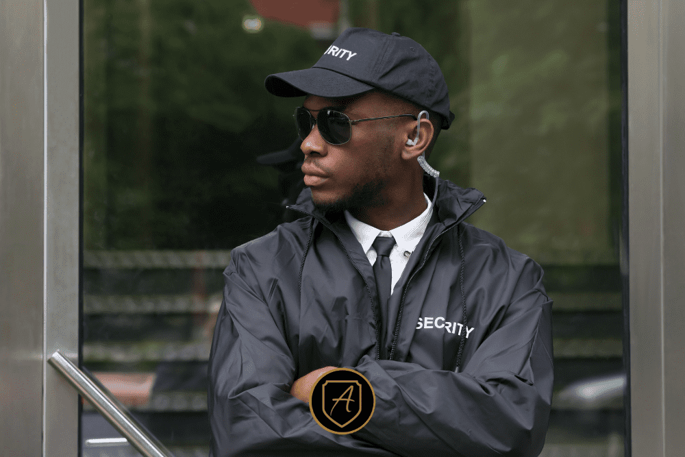 Uniformed security officer standing alert outside a building, representing proactive safety by Alexios Security Solutions